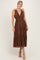 woman wearing a brown polka dot maxi dress with tie straps and a tiered skirt, styled with beige heels