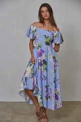 woman wearing a blue off-the-shoulder floral midi dress with puff sleeves and an asymmetrical hemline