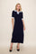 woman wearing a navy midi dress with a light blue polo collar and short sleeves, standing in black high heels
