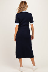 woman wearing a navy blue short sleeve maternity dress with white collar and cuffs, shown from the back