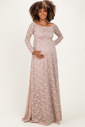 woman wearing a light pink lace maternity gown with long sleeves and a baby bump