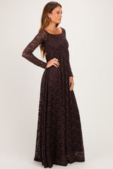 woman wearing a long sleeve burgundy lace maxi dress with a fitted bodice and flowing skirt