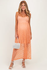 woman wearing a light orange lace maternity maxi dress with spaghetti straps and holding a white handbag, showcasing her baby bump