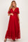 woman wearing a red lace maternity dress with short sleeves and a tie at the waist, showcasing her baby bump