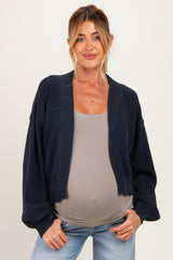 woman wearing a navy maternity cardigan over a gray top and showing her baby bump