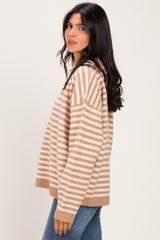 woman wearing a beige and cream striped oversized sweater with long sleeves and a relaxed fit