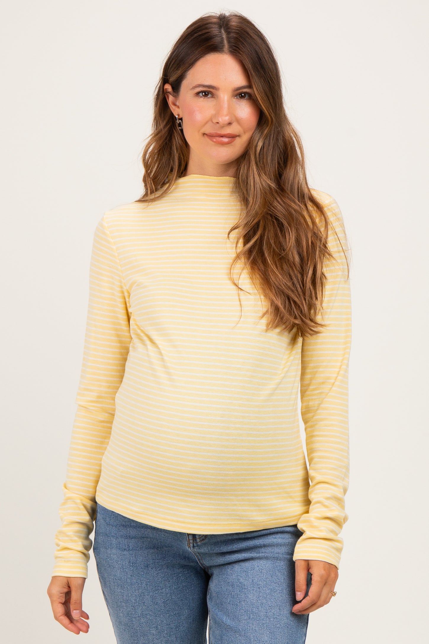 woman wearing a yellow striped maternity top with long sleeves and a relaxed fit, showing her baby bump