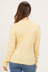 woman wearing a yellow striped long sleeve maternity top, viewed from the back, paired with blue jeans