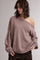 woman wearing a blush oversized off-the-shoulder sweater with wide sleeves and ribbed hem