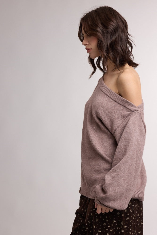 woman wearing a dusty rose off-the-shoulder oversized sweater with a relaxed fit and ribbed neckline