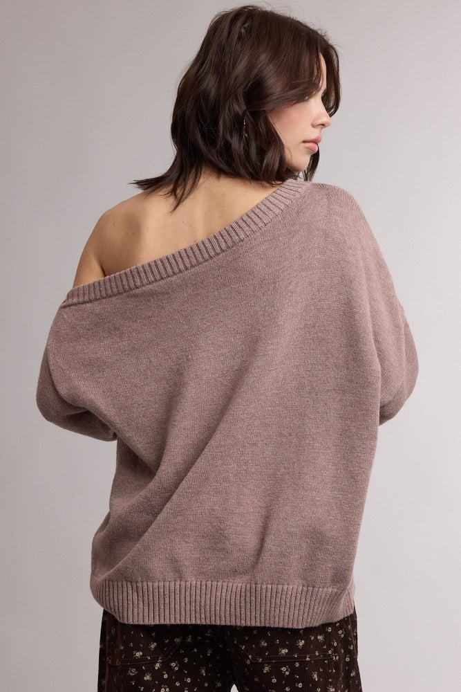 woman wearing a cozy mauve oversized sweater with an off-shoulder design and ribbed hem, seen from the back
