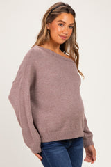 woman wearing a mauve maternity sweater with an off-the-shoulder neckline and a visible baby bump