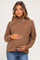 woman wearing a brown ribbed maternity sweater and holding her baby bump