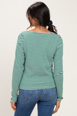 woman wearing a green and white striped long sleeve top, viewed from the back, paired with blue jeans