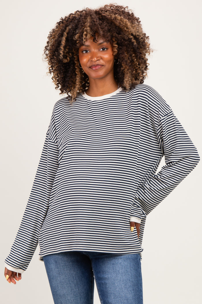 woman wearing a black and white striped long sleeve maternity top with a relaxed fit and a smile