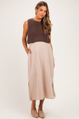 woman wearing a brown knitted maternity top over a beige maxi dress with side slits and pockets, showing a baby bump