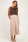 woman wearing a brown knitted maternity top over a beige maxi dress with side slits and pockets, showing a baby bump