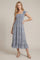 woman wearing a blue patterned midi dress with ruffle sleeves and a tiered hem