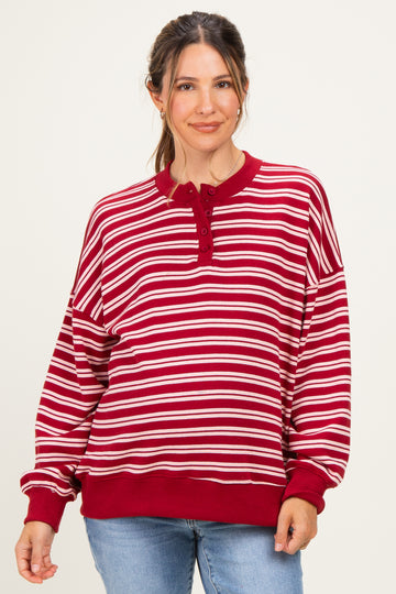 woman wearing a red and white striped maternity sweatshirt with a henley neckline and relaxed fit