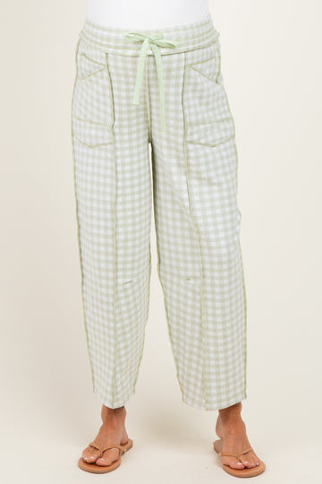woman wearing green and white gingham maternity pants with pockets and a drawstring waist
