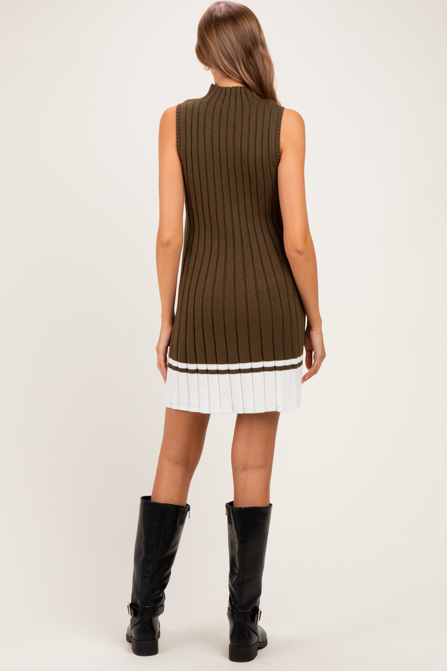 woman wearing a brown sleeveless maternity dress with ribbed texture and white pleated hem