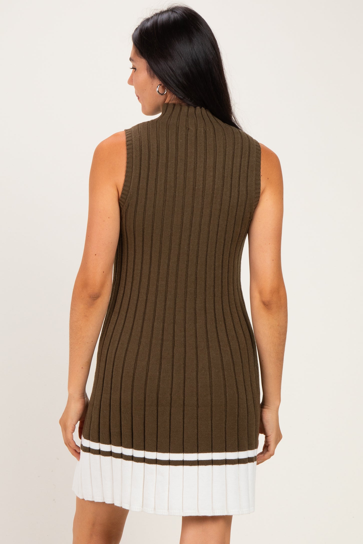 woman wearing a sleeveless olive green ribbed knit dress with a white striped hem