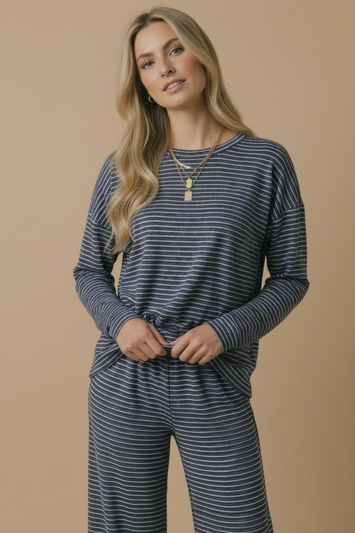 woman wearing a navy blue and white striped long sleeve top with a relaxed fit and matching wide-leg pants
