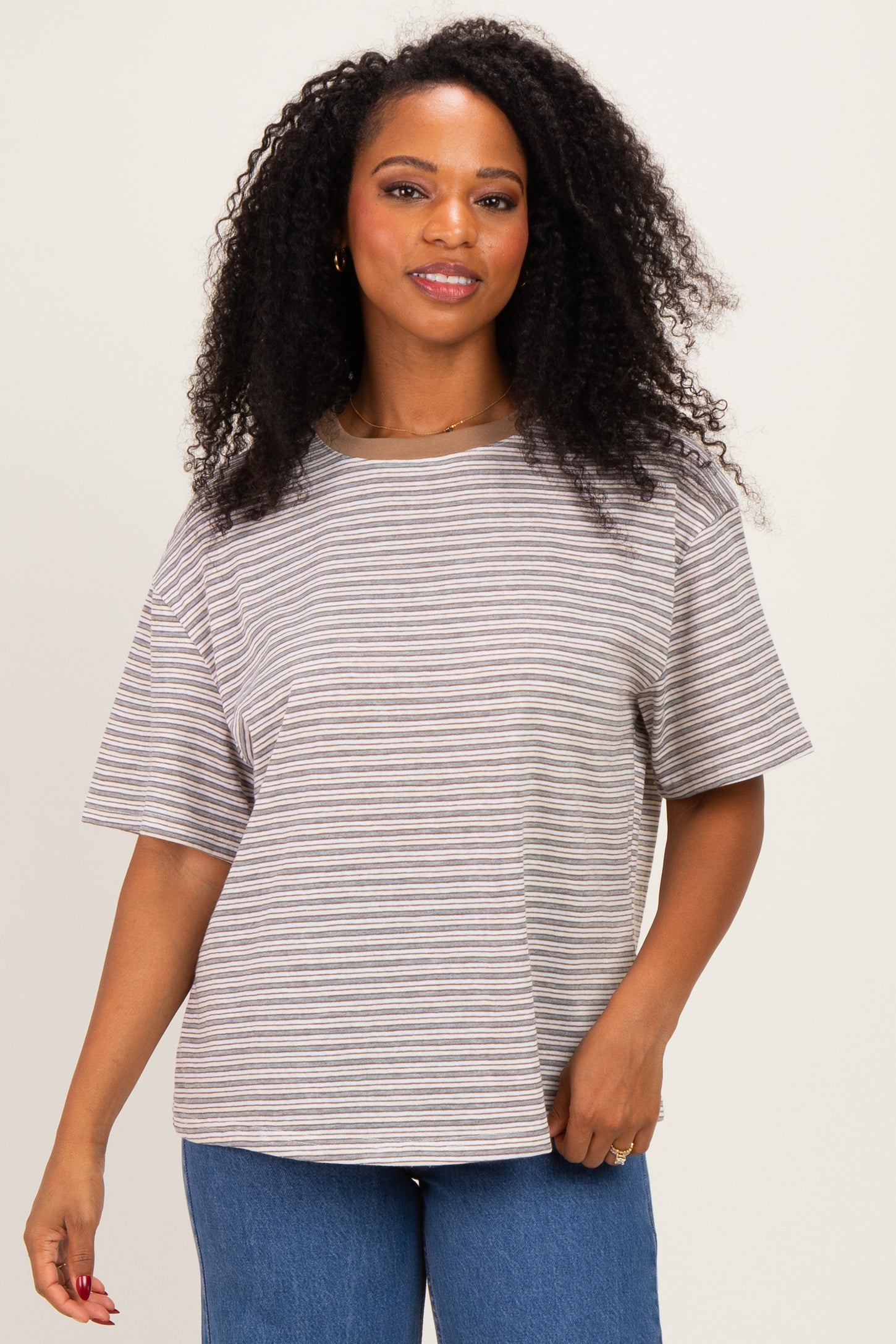 woman wearing a beige and brown striped oversized t-shirt with short sleeves and a relaxed fit