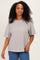 woman wearing a beige and brown striped oversized t-shirt with short sleeves and a relaxed fit