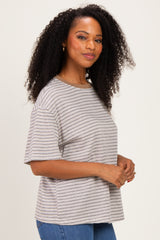 woman wearing a striped short sleeve t-shirt in neutral tones with a relaxed fit and curly hair