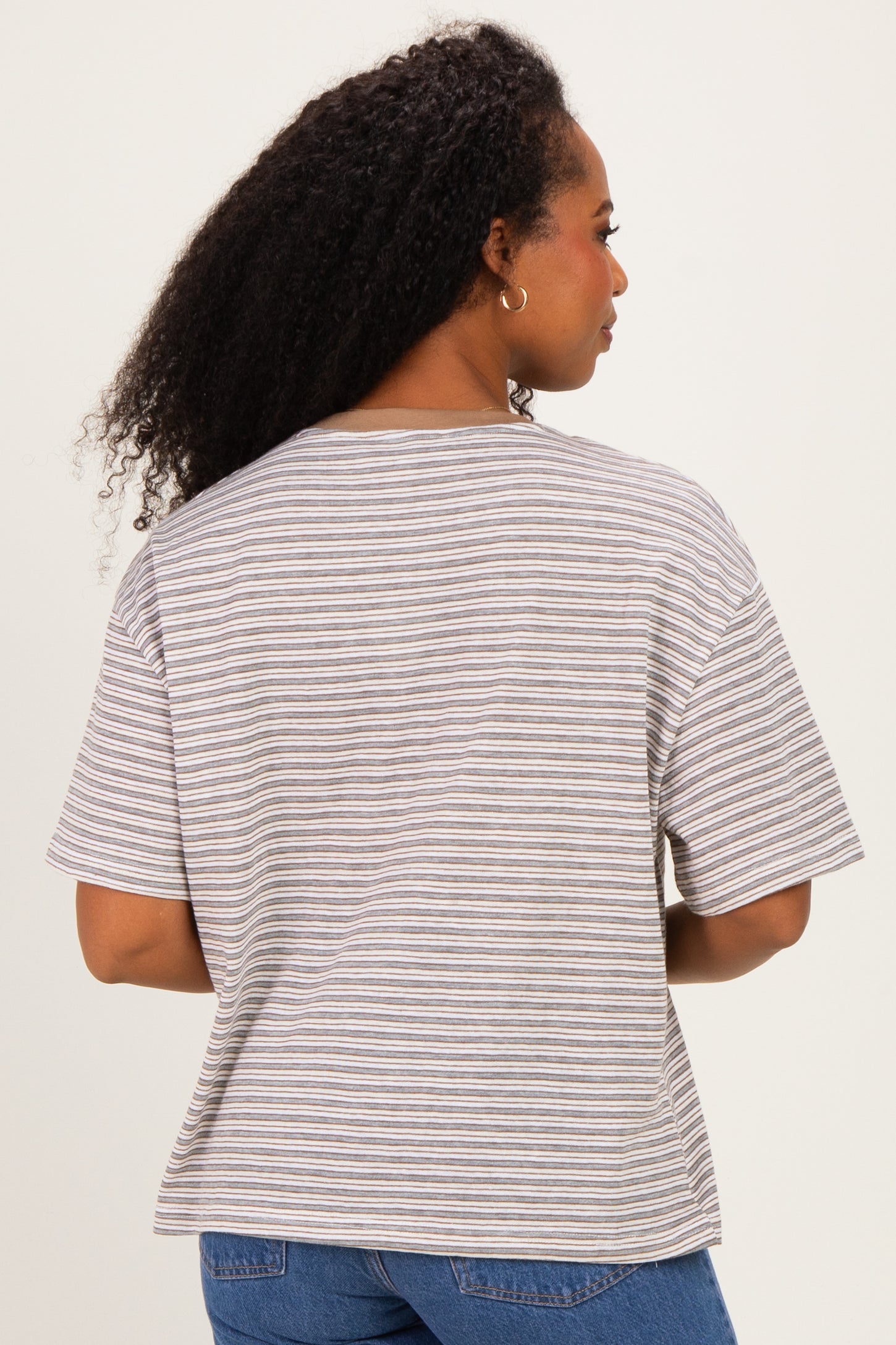 woman wearing a striped short sleeve top with a relaxed fit, showing the back view