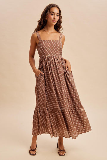 woman wearing a brown polka dot maxi dress with a square neckline and pockets