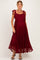 woman wearing a burgundy lace maternity dress with tied shoulder straps and a flowing skirt, showcasing her baby bump