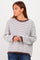 woman wearing a white and brown striped oversized sweater with long sleeves and a relaxed fit