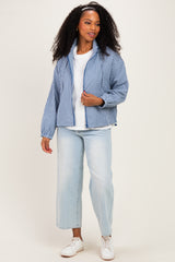 woman wearing a blue and white gingham check puffer jacket, white t-shirt, light wash wide-leg jeans, and white sneakers
