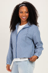 woman wearing a blue and white gingham cropped jacket with a zipper and front pockets