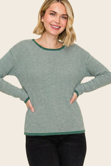 woman wearing a green and white striped long sleeve top with a relaxed fit and ribbed cuffs