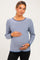 woman wearing a navy and white striped maternity top, gently cradling her baby bump