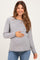 woman wearing a gray and white striped long sleeve maternity top and holding her baby bump