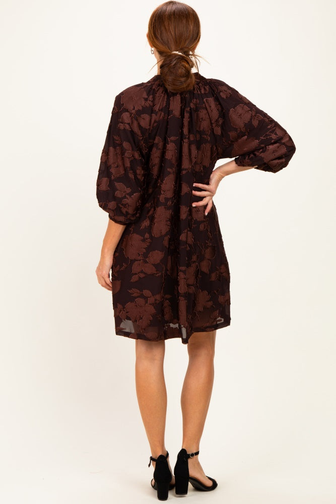 woman wearing a brown floral print puff sleeve dress, showing the back with a cinched waist and gathered neckline