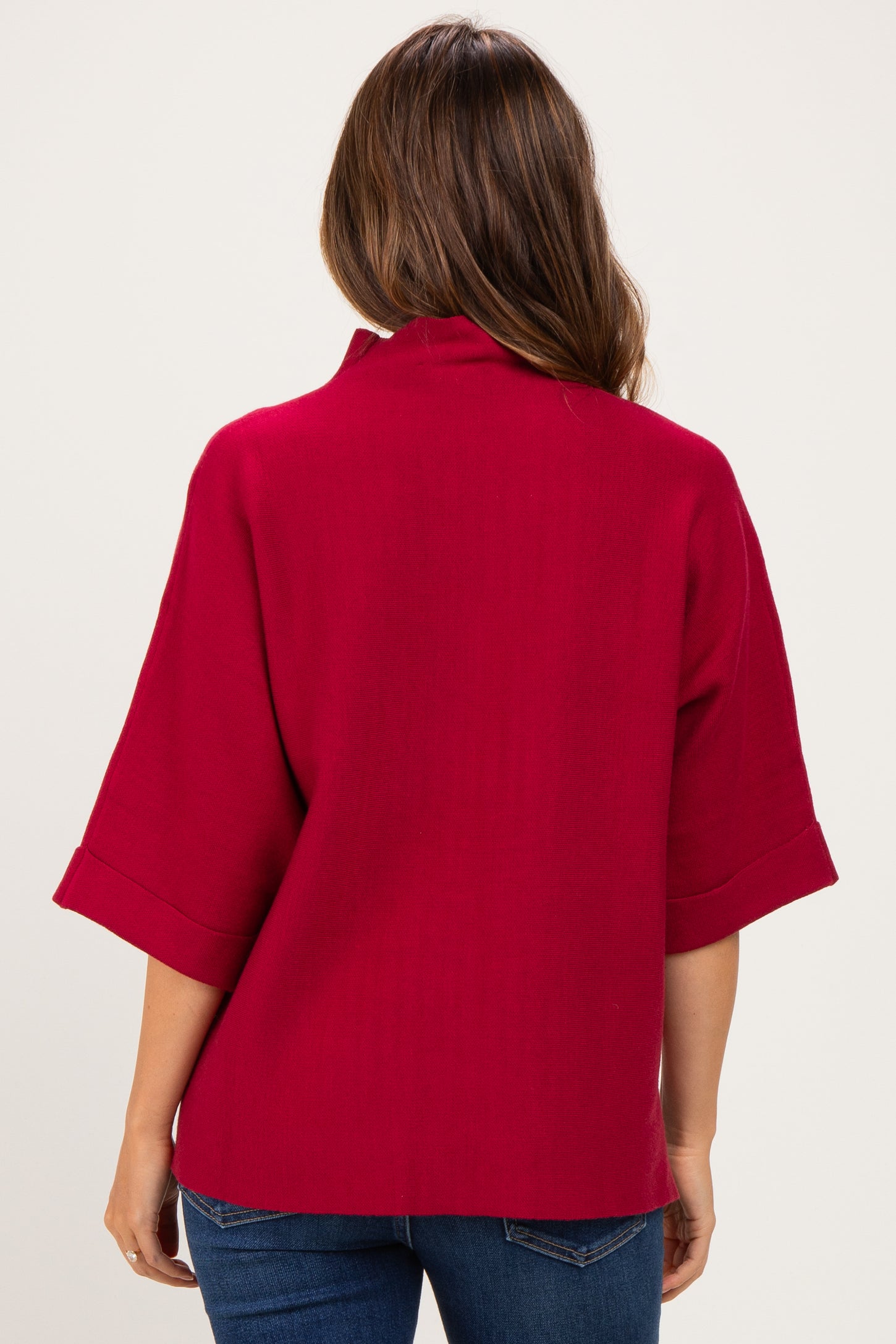 woman wearing a red maternity top with a relaxed fit and wide sleeves, viewed from the back