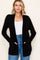 woman wearing a black open-front cardigan with pockets and a white tank top, styled with high-waisted jeans