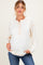 woman wearing a cream maternity top with a henley neckline and orange stitching, showing her baby bump