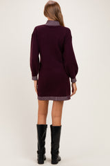 woman wearing a burgundy maternity sweater dress with striped collar and cuffs, seen from the back