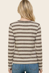 woman wearing a striped long sleeve top in beige and brown, seen from the back with light blue jeans