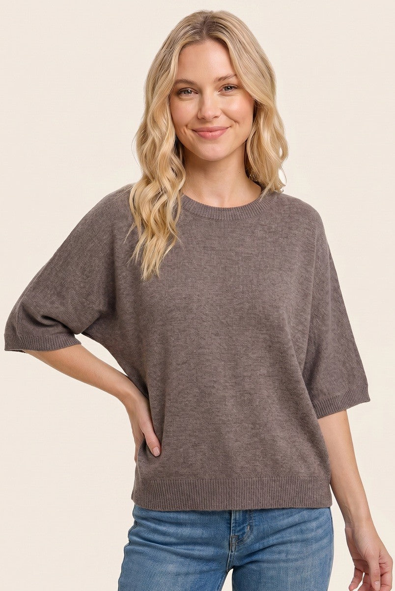 woman wearing a relaxed fit brown short sleeve sweater with a rounded neckline and a casual pose