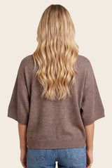 woman wearing a brown oversized sweater with short sleeves, seen from the back
