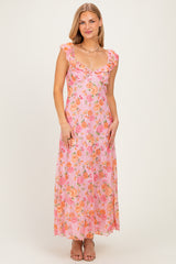 woman wearing a pink floral maxi dress with ruffled straps and a deep v-neckline
