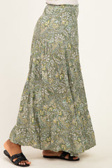 woman wearing a green bohemian maxi skirt with an intricate floral pattern and smocked waistband
