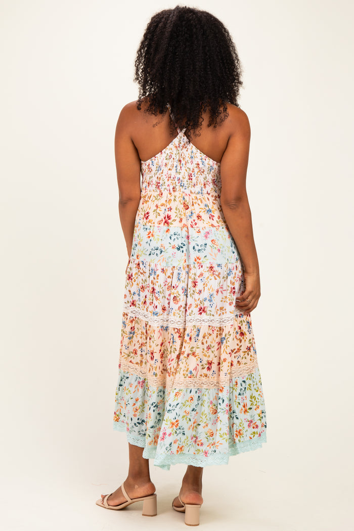 woman wearing a flowy multicolor floral maxi dress with a smocked back and adjustable straps